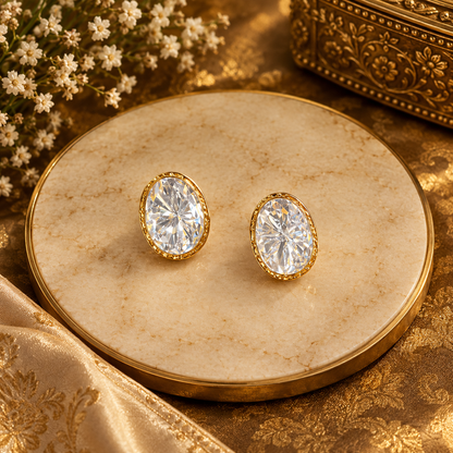 Gold-finish oval kundan polki stud earrings with a clear starburst cut stone in a gold bezel