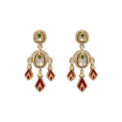 Gold-tone kundan necklace set with red kite-shaped drops, green accent stones and matching chandelier earrings on a grey display bust
