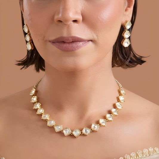 Gold plated hexagon zircon necklace set with matching drop earrings on a cream background