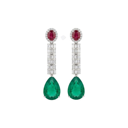 Silver-tone American diamond long drop earrings with ruby-red oval top stones, clear baguette stone rows and large emerald-green pear-cut drops on dark green velvet