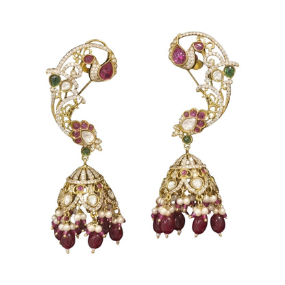 Gold plated ruby maroon ear cuff peacock jhumka earrings with American diamond stones, maroon beads and pearl hangings on a white background