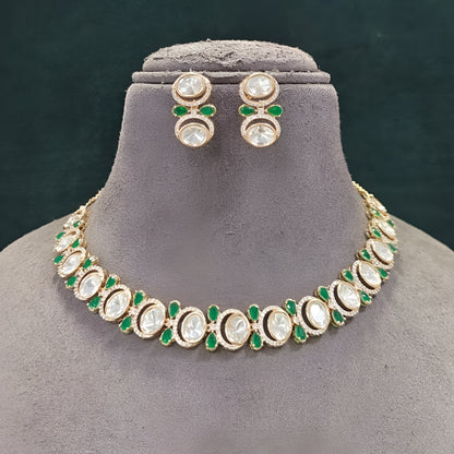 Gold-tone green kundan choker necklace set with oval kundan stones, green pear-shaped accents and matching stud drop earrings on a grey display bust