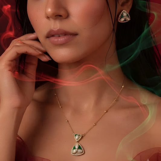 "Gold-tone triangular pendant necklace and earring set with green enamel detailing and marquise-cut clear crystal accents, on white background"
