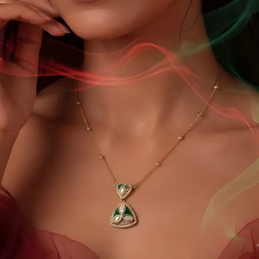 "Gold-tone triangular pendant necklace and earring set with green enamel detailing and marquise-cut clear crystal accents, on white background"