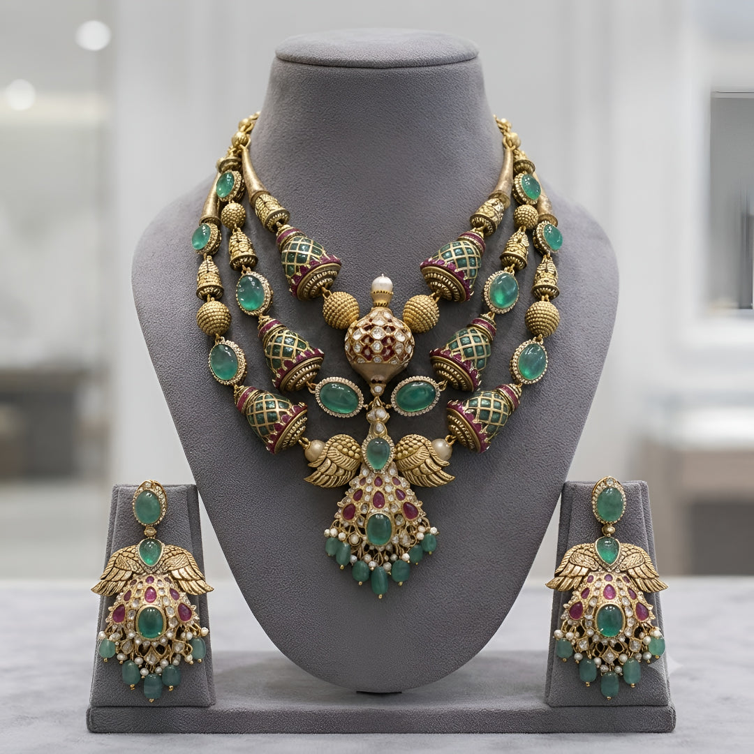"Antique gold plated kundan polki bridal necklace set with emerald and ruby stones, peacock wing pendant design, and matching jhumka earrings"