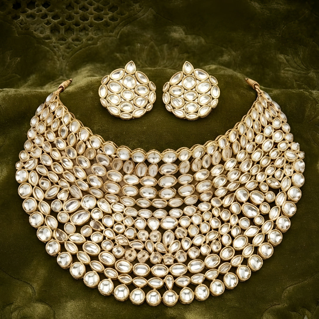 "Gold-tone kundan studded bib-style bridal necklace set with matching round stud earrings on white background"