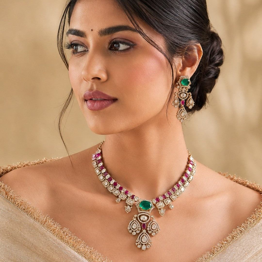 Gold-plated Kundan necklace set with green emerald-look center stone, pink ruby accents and matching American diamond earrings for bridal and wedding wear.