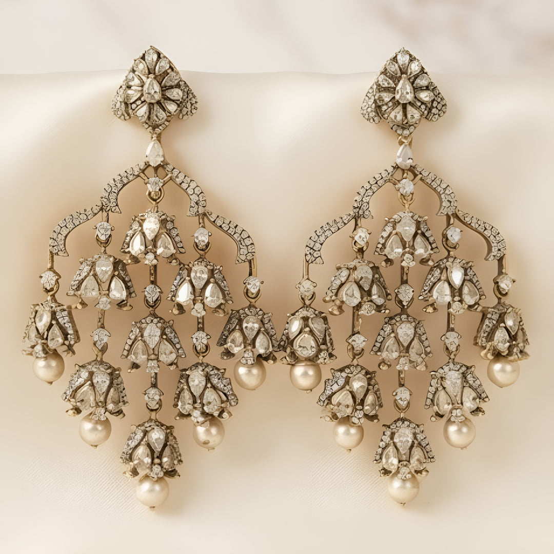 "Antique oxidized Polki-style chandelier earrings with multi-tier floral clusters and pearl drops, front-facing pair on white background"
