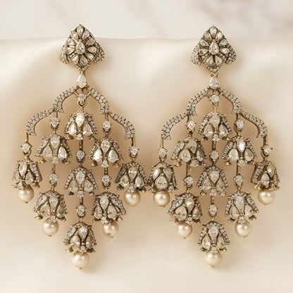 "Antique oxidized Polki-style chandelier earrings with multi-tier floral clusters and pearl drops, front-facing pair on white background"