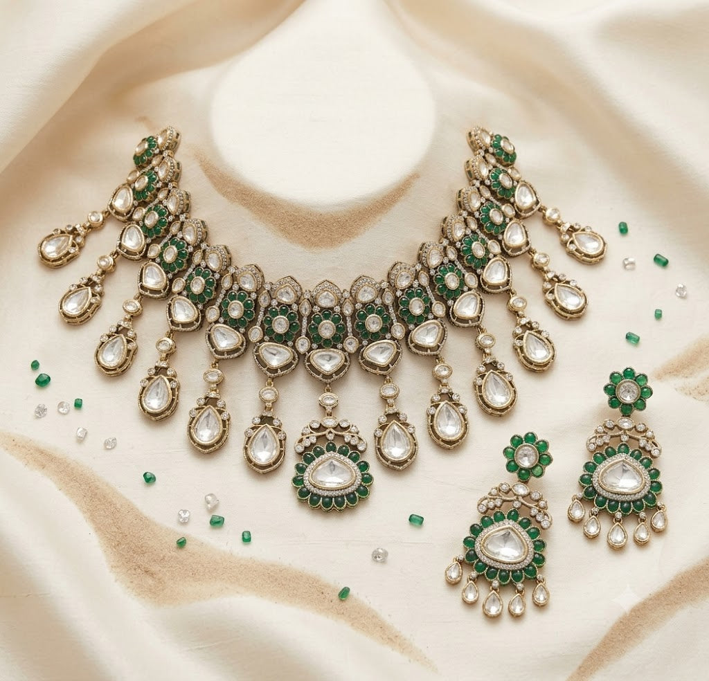 Antique gold Victorian kundan bridal choker with emerald-green flower medallions, pear-stone drops and a matching drop earring on a grey display bust