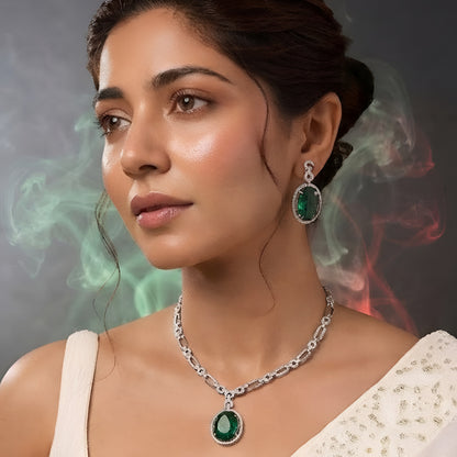 Silver plated American Diamond necklace set with emerald green oval pendant and matching drop earrings on white background