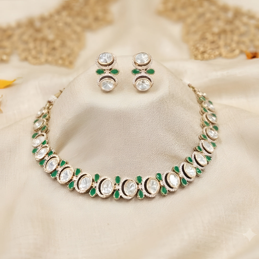 Gold-tone green kundan choker necklace set with oval kundan stones, green pear-shaped accents and matching stud drop earrings on a grey display bust
