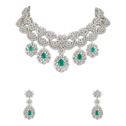 "Silver rhodium-plated bridal necklace set with white American diamonds and green emerald drop stones, paired with matching floral drop earrings"