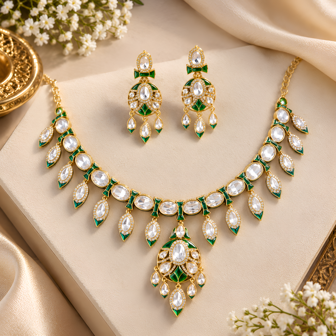 Gold-tone green meenakari kundan necklace set with round centre pendant, leaf-shaped drops and matching drop earrings on a grey display bust