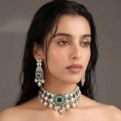 "Antique gold Kundan choker necklace with cushion-cut emerald center and polki teardrop drops, matching chandelier earrings"
