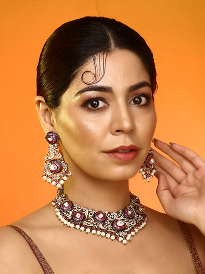 Gold-tone traditional necklace set with pink kundan-style stones, intricate detailing, pearl bead drops, and matching ornate dangling earrings.
