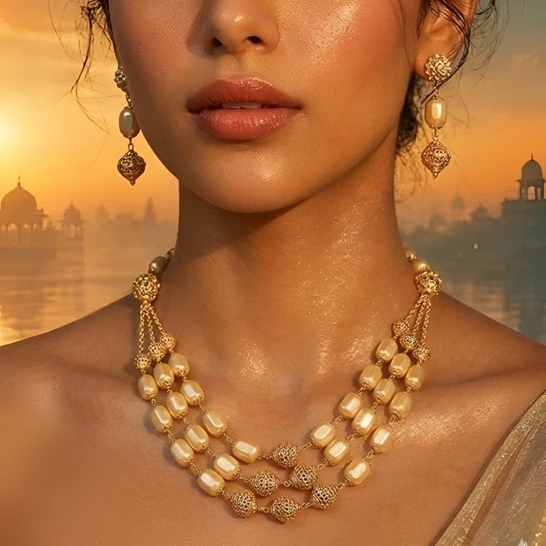 Elegant multi-layer ivory pearl beaded necklace set with gold-tone filigree accents and matching drop earrings for women.