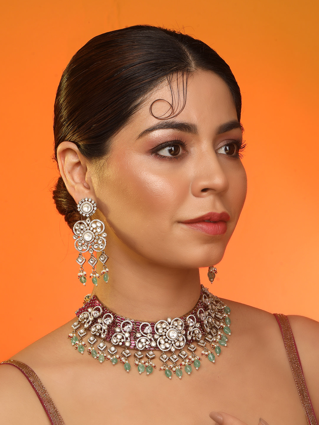 Kundan bridal necklace set with pink stones, green bead drops, and matching statement earrings in gold tone
