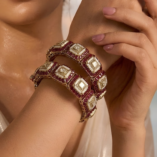 Gold-plated designer kada bangles with ruby-red stones and white crystal square motifs for women.