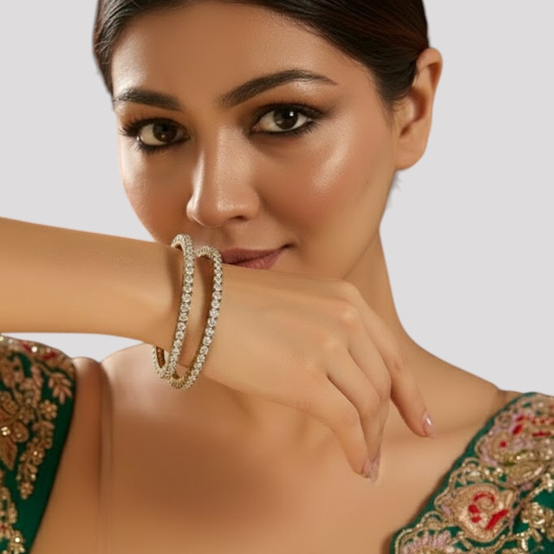 "Close-up of a woman wearing stone-studded crystal bangles, dressed in a green embroidered outfit."