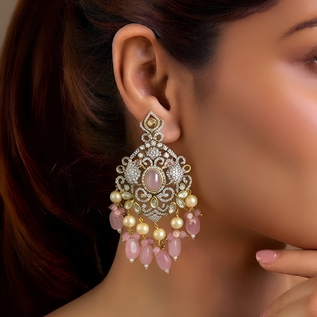 Pink Kundan Chandbali earrings featuring a blush pink center stone, sparkling Kundan detailing, pearl drops, and pink bead tassels with a gold-plated finish.