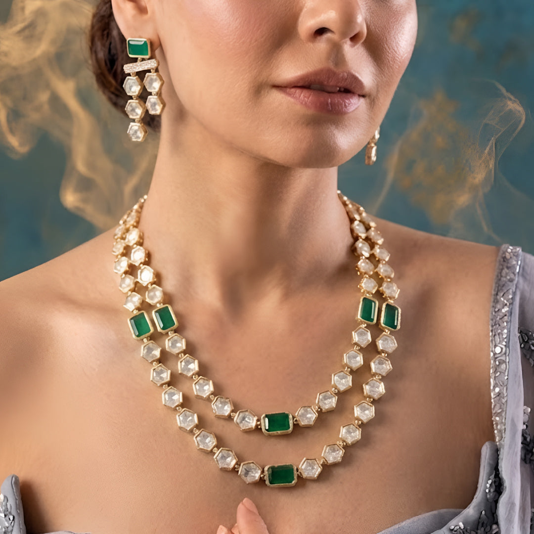 Gold-plated double-layer Kundan necklace set featuring emerald green rectangular stones, Polki-style hexagonal stones, and matching drop earrings for women.