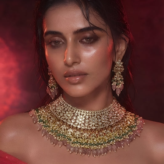 "Antique gold bib-style kundan necklace with matching floral earrings"