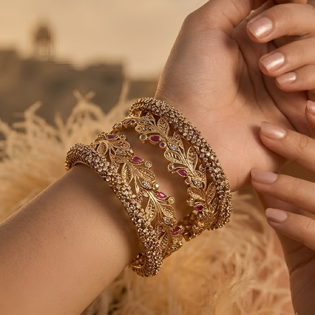 Gold-plated leaf design kada bangles with red and white stone embellishments for women.