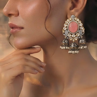 Pink Kundan jhumka earrings with antique gold finish, oval pink stone, sparkling Kundan crystals, and pearl tassel drops for bridal and festive wear.