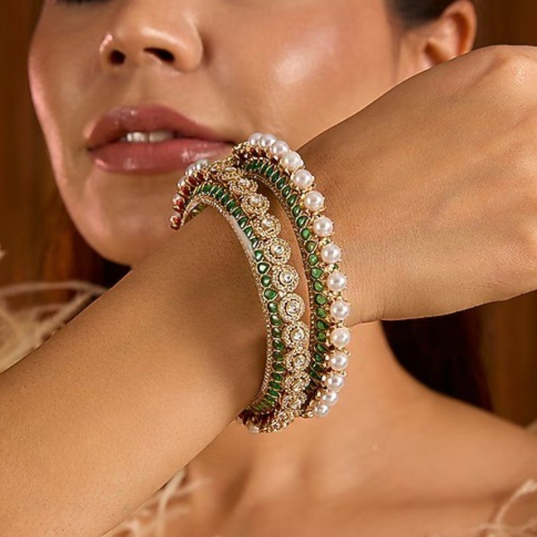 Gold-plated green Kundan bangles with pearl border and sparkling white stones for women.