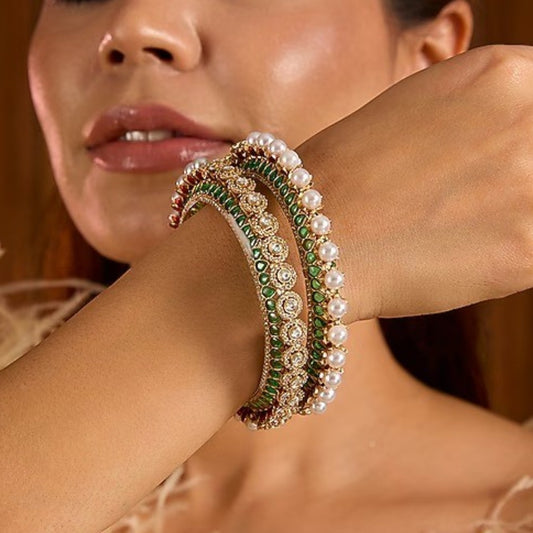 Gold-plated green Kundan bangles with pearl border and sparkling white stones for women.