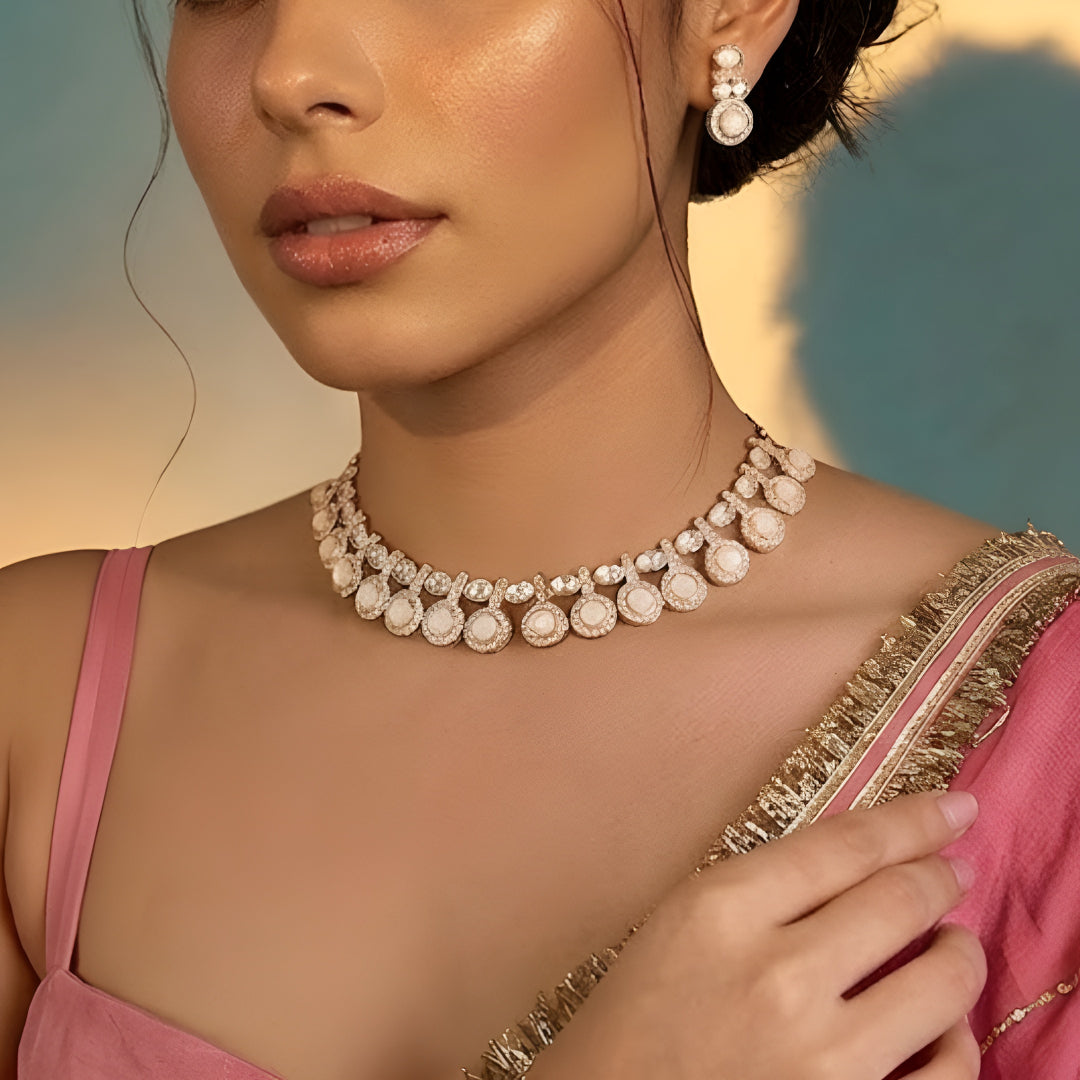 Gold-tone statement necklace set with ivory cabochon stones, crystal embellishments, and matching earrings on white background.