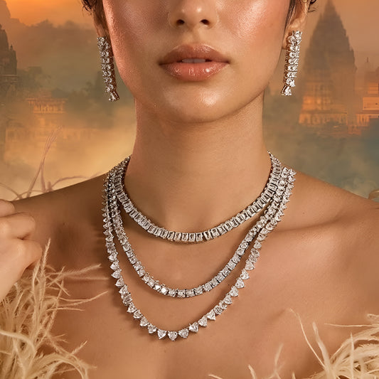 Silver-tone layered crystal necklace with matching drop earrings featuring sparkling clear stones in an elegant bridal jewelry design.