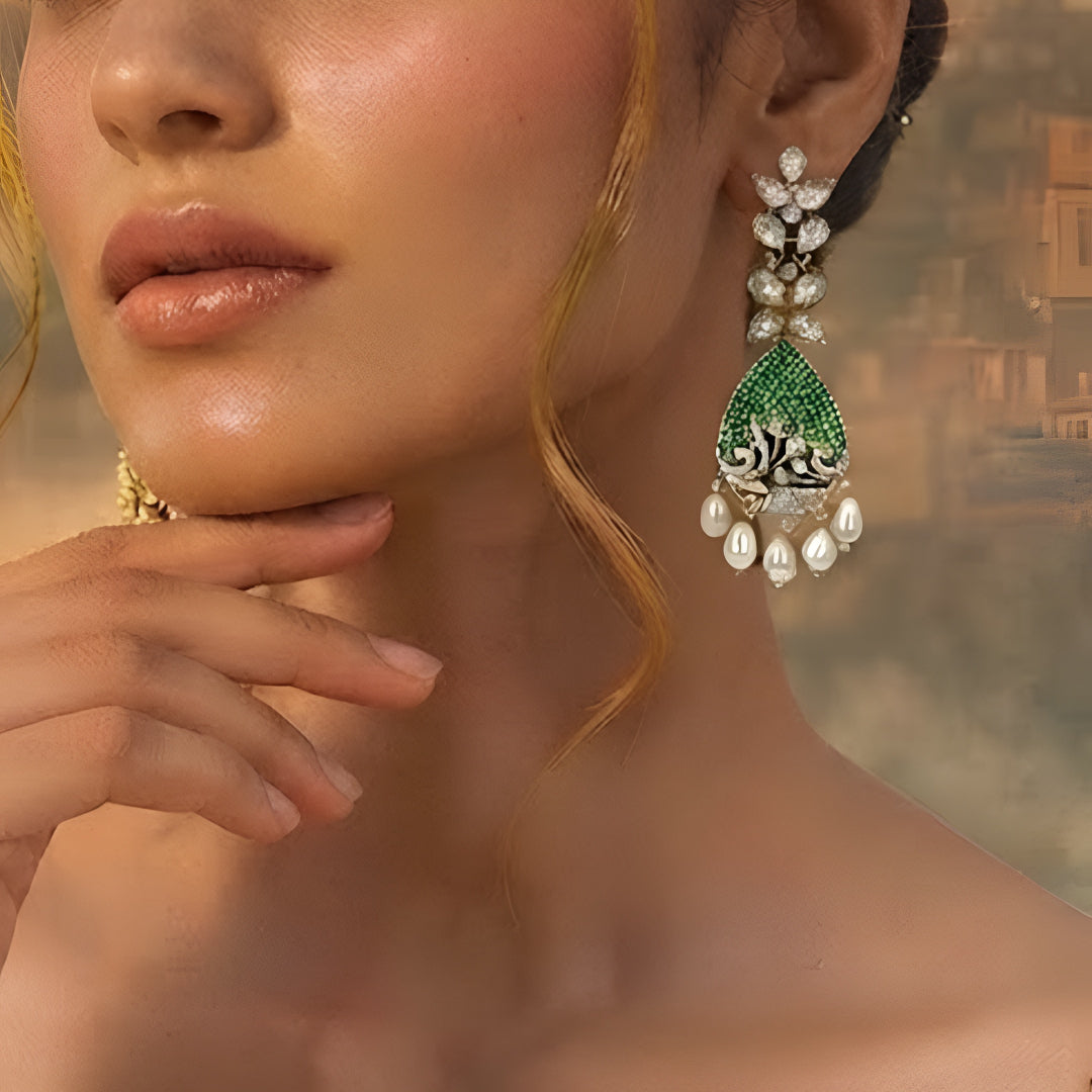 Luxury gold-plated teardrop earrings with emerald green stones, sparkling American diamonds, and pearl drop danglers for women.