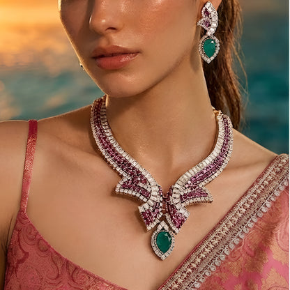 Luxury emerald, ruby and diamond necklace set with matching earrings in white gold featuring pear-shaped emerald gemstones, pink ruby accents and sparkling diamond detailing.