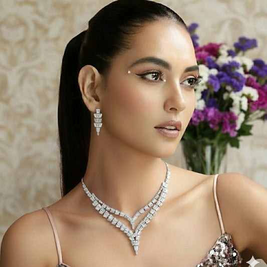 Elegant American Diamond necklace set displayed on a red velvet stand, featuring a double-layered V-shaped necklace with matching earrings, perfect for bridal or party wear.