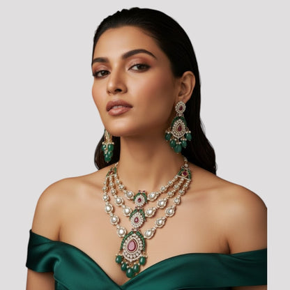 "Triple-layer gold-finish necklace set with ruby stones, green accents, AD detailing, pastel green bead drops, and matching earrings displayed on a light background."