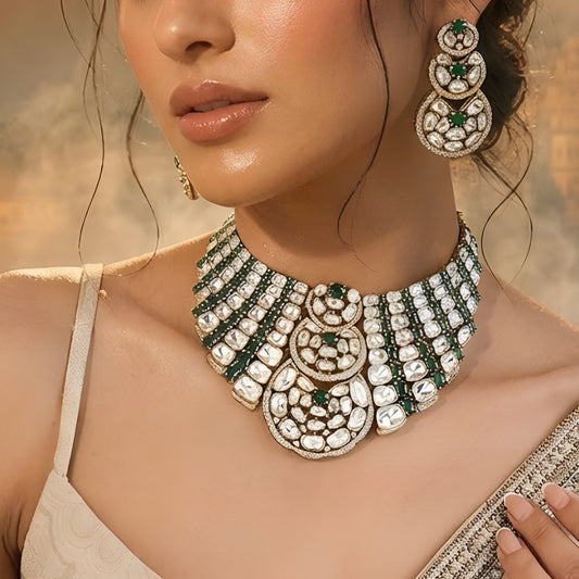 Luxury Kundan Polki necklace set with matching earrings featuring uncut Polki diamonds, green emerald accents, and traditional bridal jewelry craftsmanship in a gold finish.