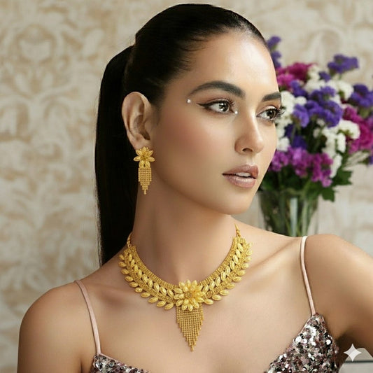 Gold-plated traditional floral necklace set with matching earrings on red display stand – bridal and festive Indian jewelry