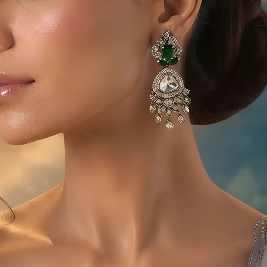 Luxury gold-plated statement earrings with emerald green stones, Kundan stones, sparkling American diamonds, and teardrop danglers for women.