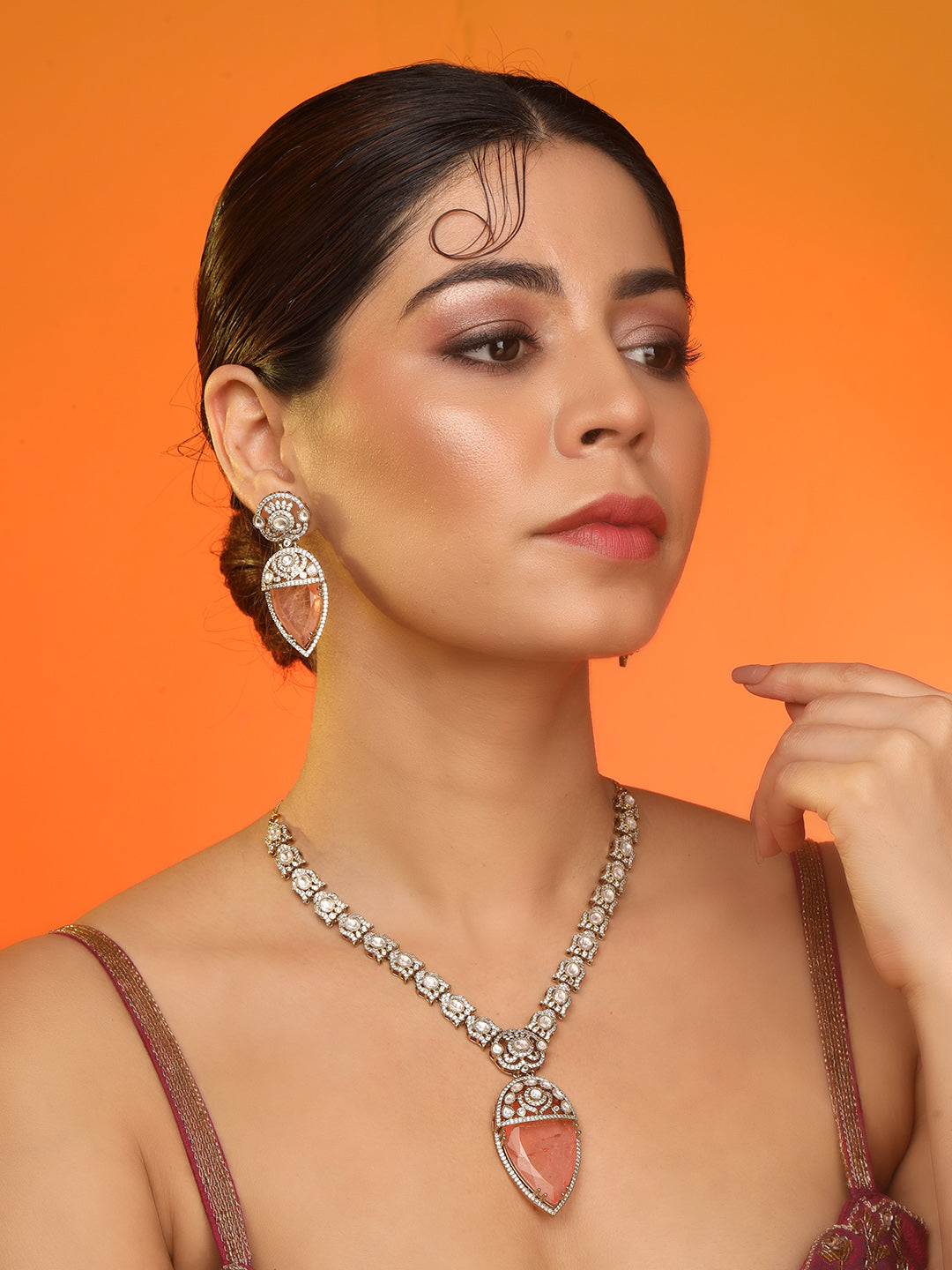 Gold-plated necklace set with peach teardrop pendant and matching statement earrings for bridal and festive wear