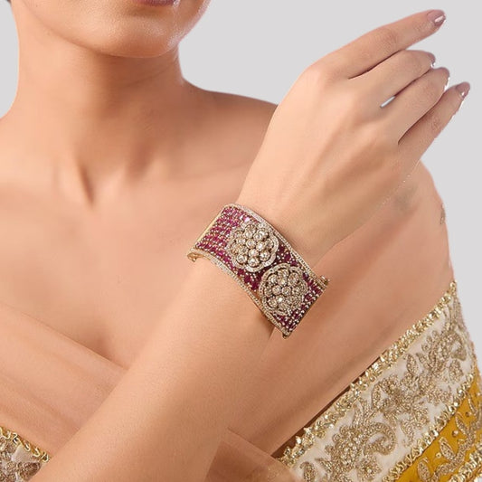 Woman wearing gold-plated ruby kundan floral bracelet kada