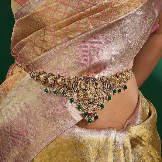 Traditional gold plated Lakshmi temple waist belt (Vaddanam) with green bead drops and pearl accents for bridal, wedding, festive, and classical dance wear.