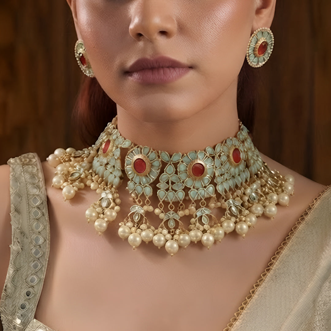 Traditional gold-plated Kundan pearl choker necklace set with ruby-red stones and matching stud earrings for women.