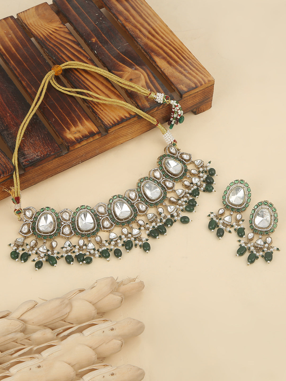 Elegant gold-tone choker necklace set with large mirror-polished stones, green bead accents, and pearl detailing, paired with matching dangling earrings