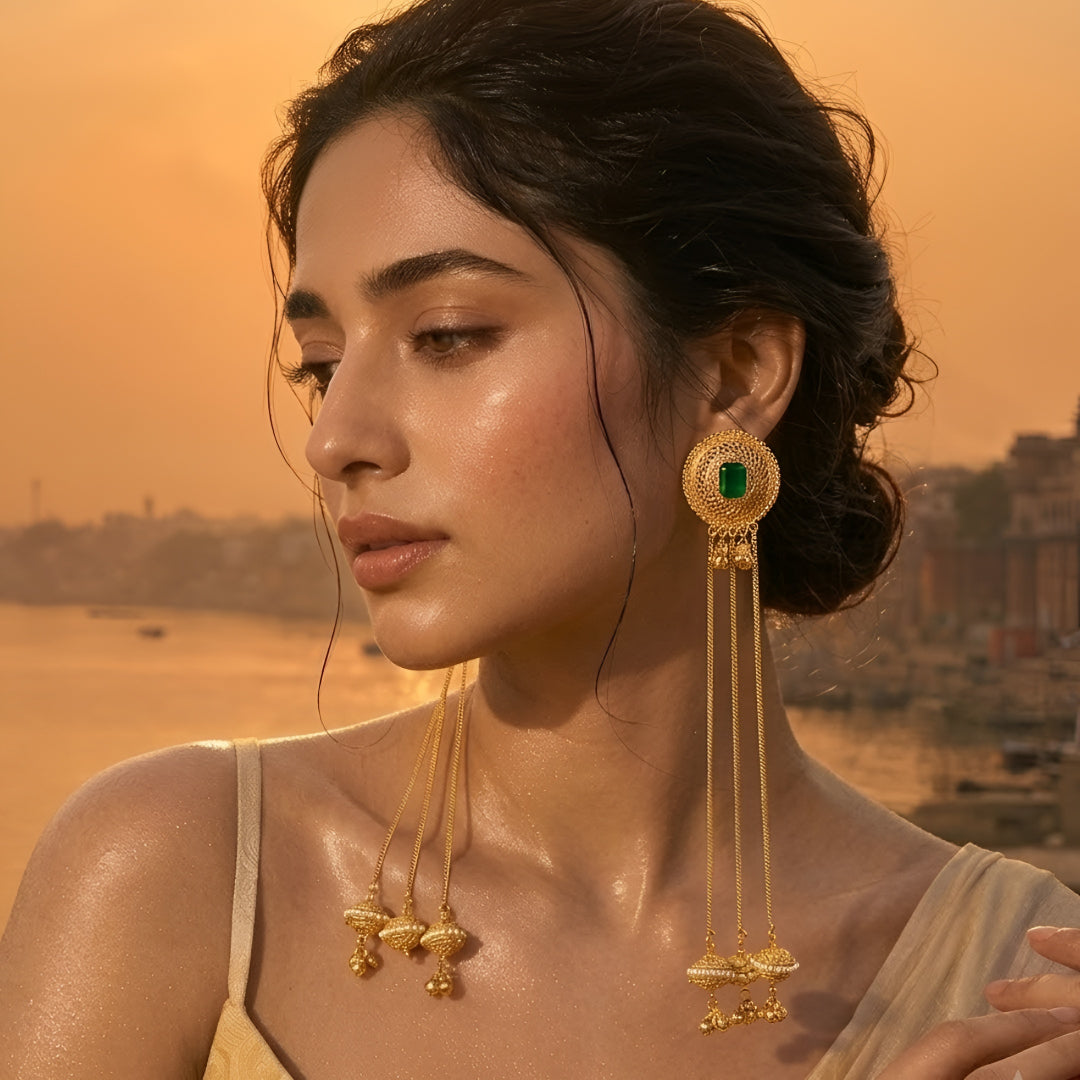 Traditional gold plated long chain tassel earrings with green stone stud and pearl jhumka drops for women, ideal for bridal, wedding, festive, and ethnic wear.