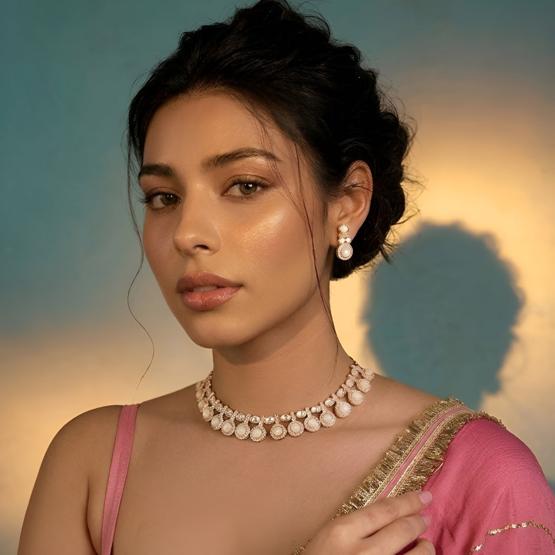 Gold-tone statement necklace set with ivory cabochon stones, crystal embellishments, and matching earrings on white background.