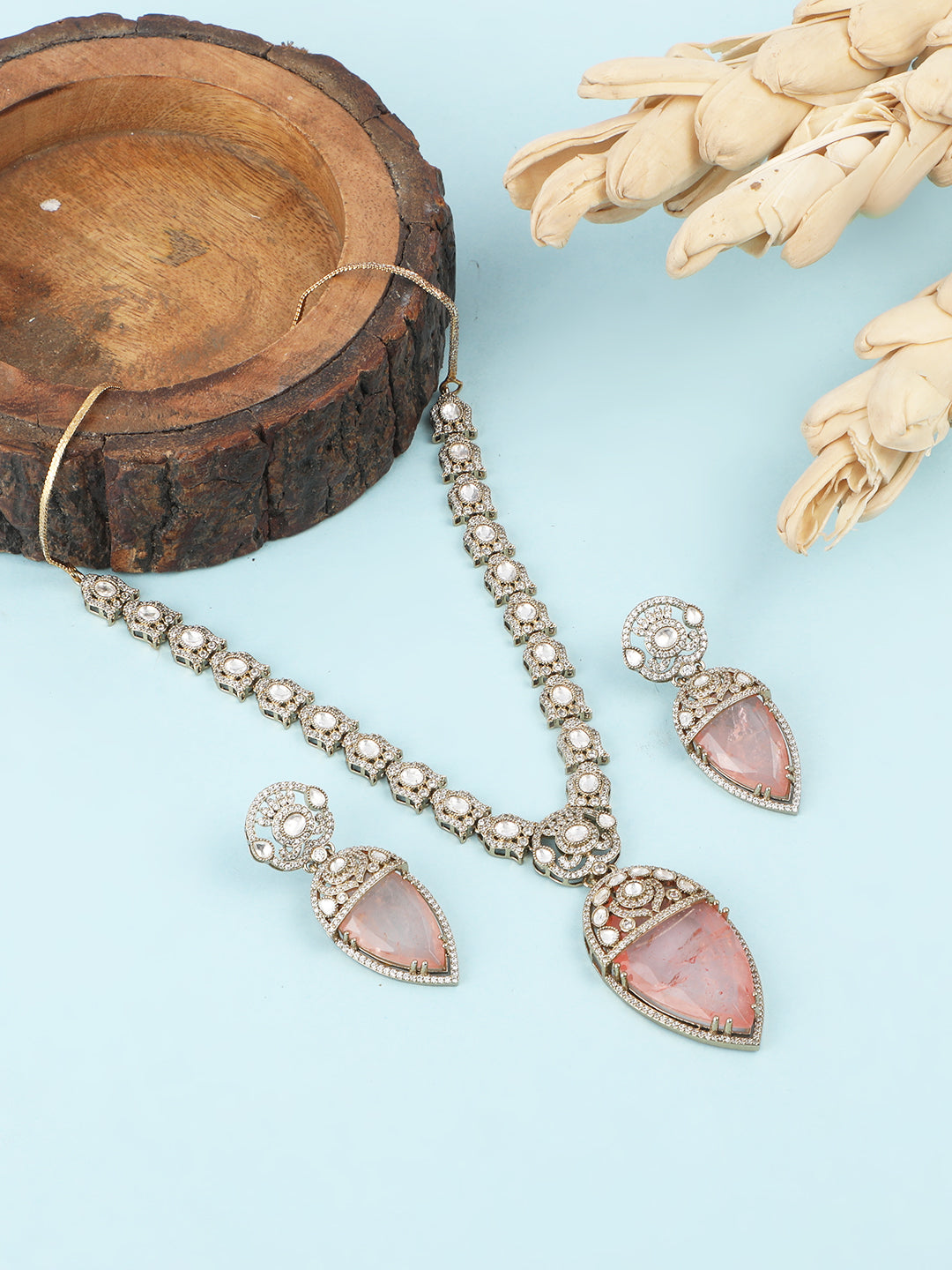 Gold-plated necklace set with peach teardrop pendant and matching statement earrings for bridal and festive wear
