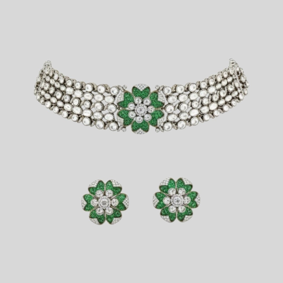 "Green floral American Diamond choker necklace set with matching stud earrings, featuring white AD stones, gold finish and adjustable yellow dori, displayed on a dark background."