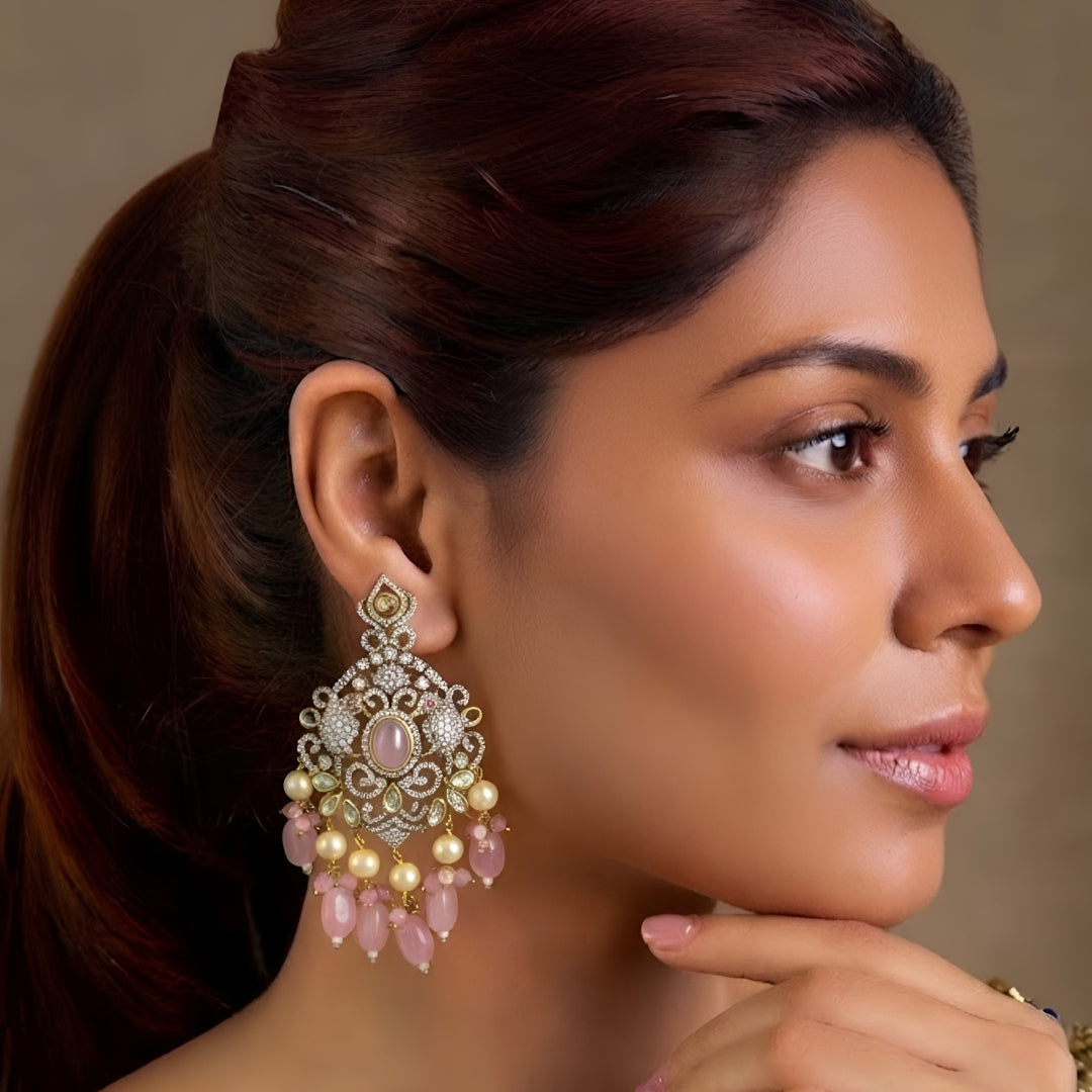 Pink Kundan Chandbali earrings featuring a blush pink center stone, sparkling Kundan detailing, pearl drops, and pink bead tassels with a gold-plated finish.